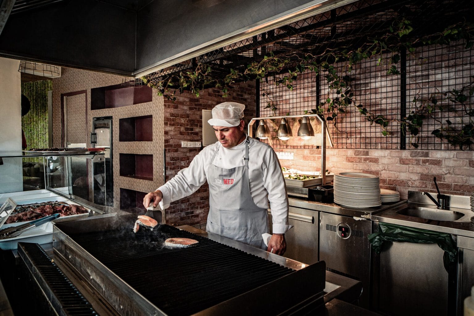 Chef at the grill and brick oven station, Malama Beach Holiday Village, Protaras