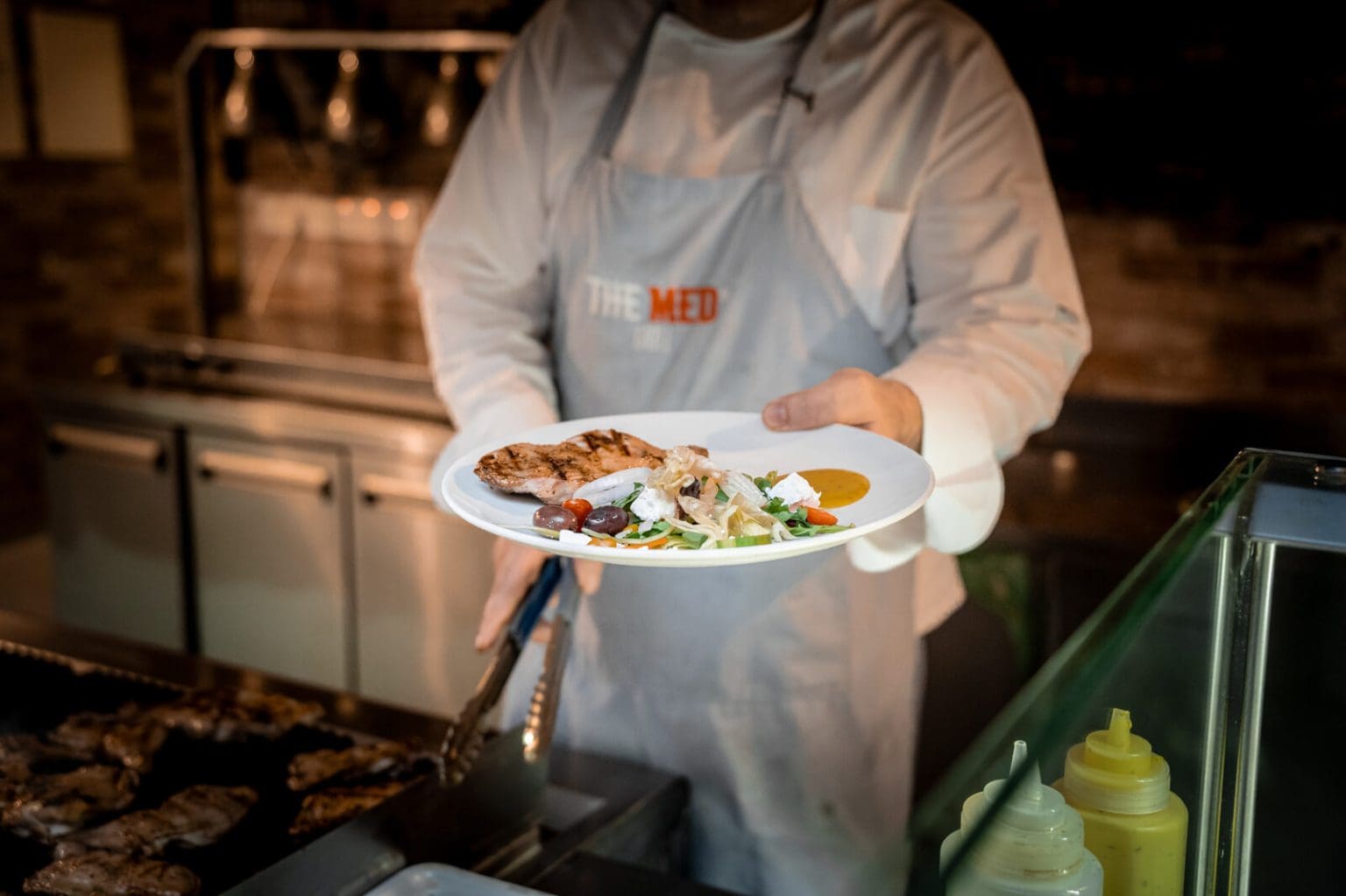 Chef plating at the Med Grill station, Malama Beach Holiday Village, Protaras